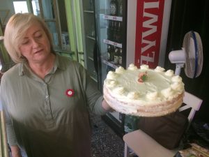 Szefowa Herabciarni Teatralnej prezentuje upieczony przez siebie biało-czerwony tort
